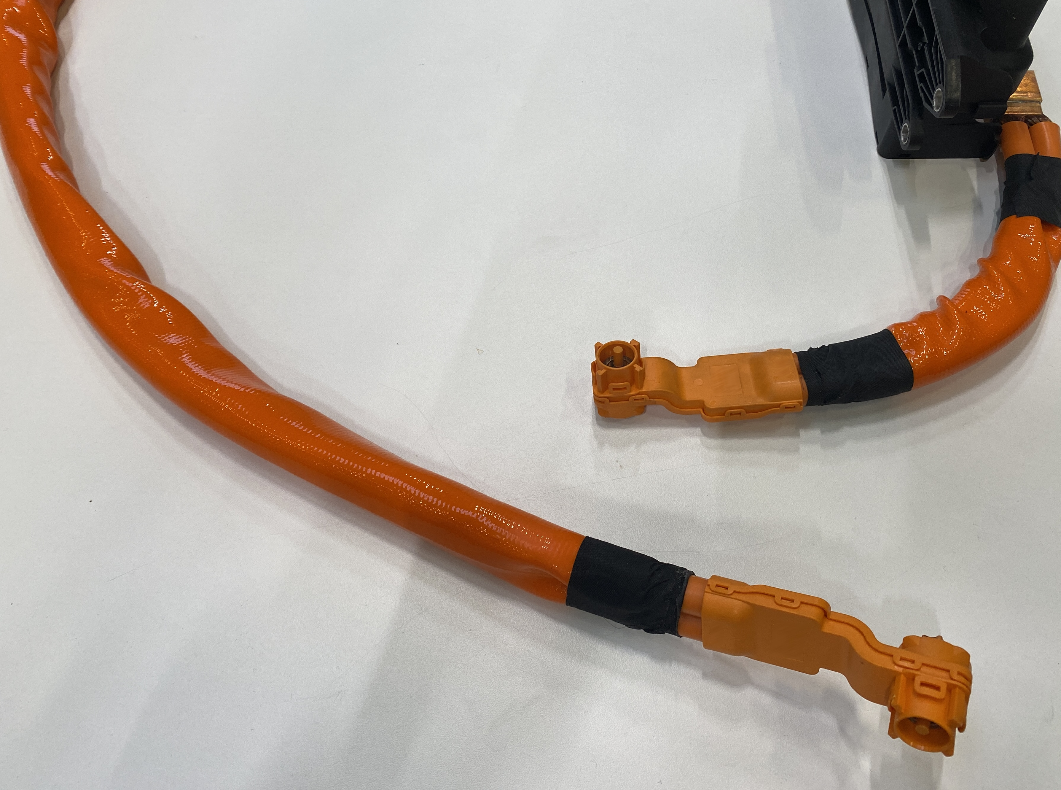 Orange high-voltage cables of an electric vehicle with insulated plug connections for safe energy transfer in the high-voltage system.