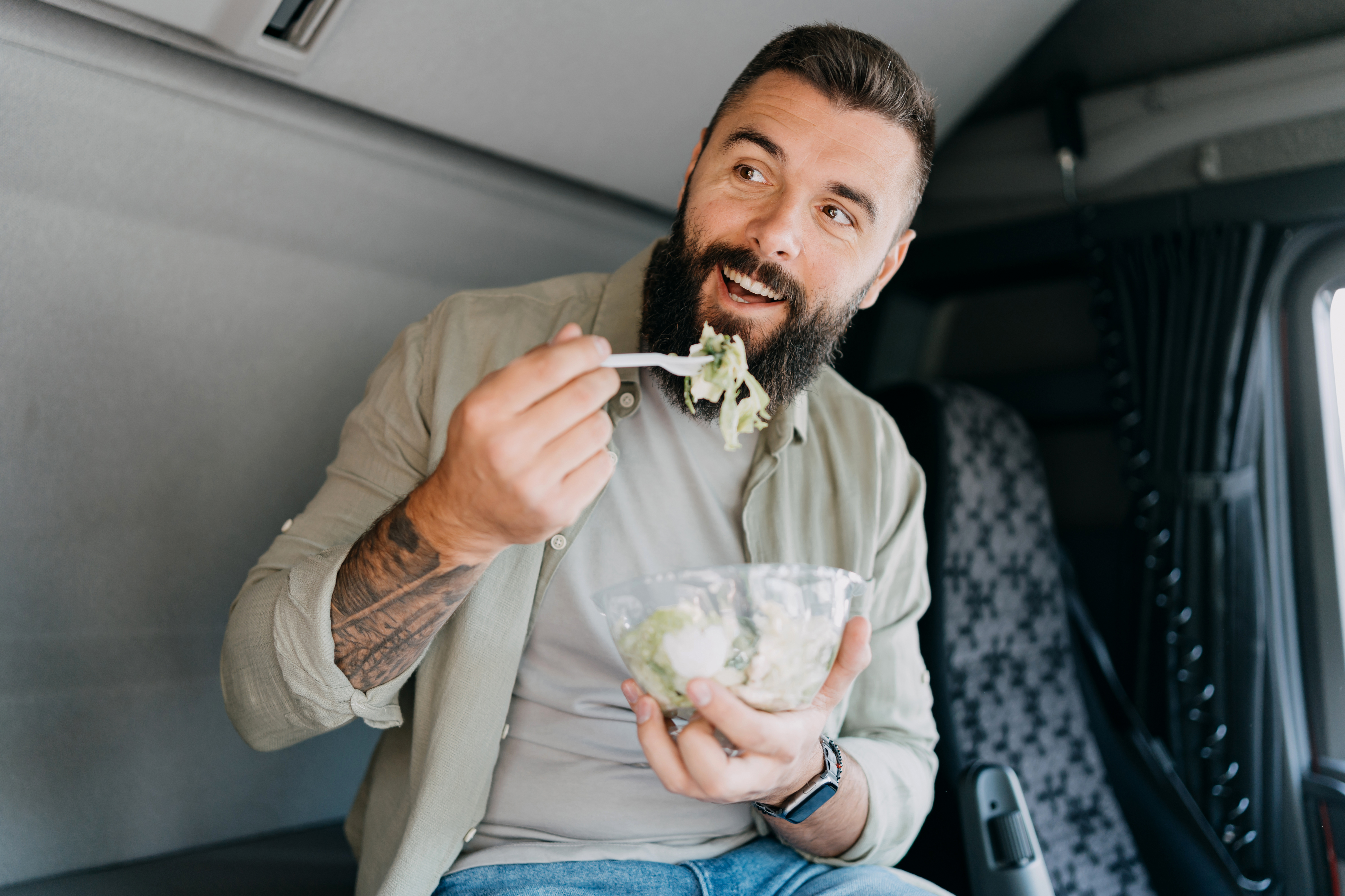 Un conducente di autocarri mentre mangia un'insalata sana
